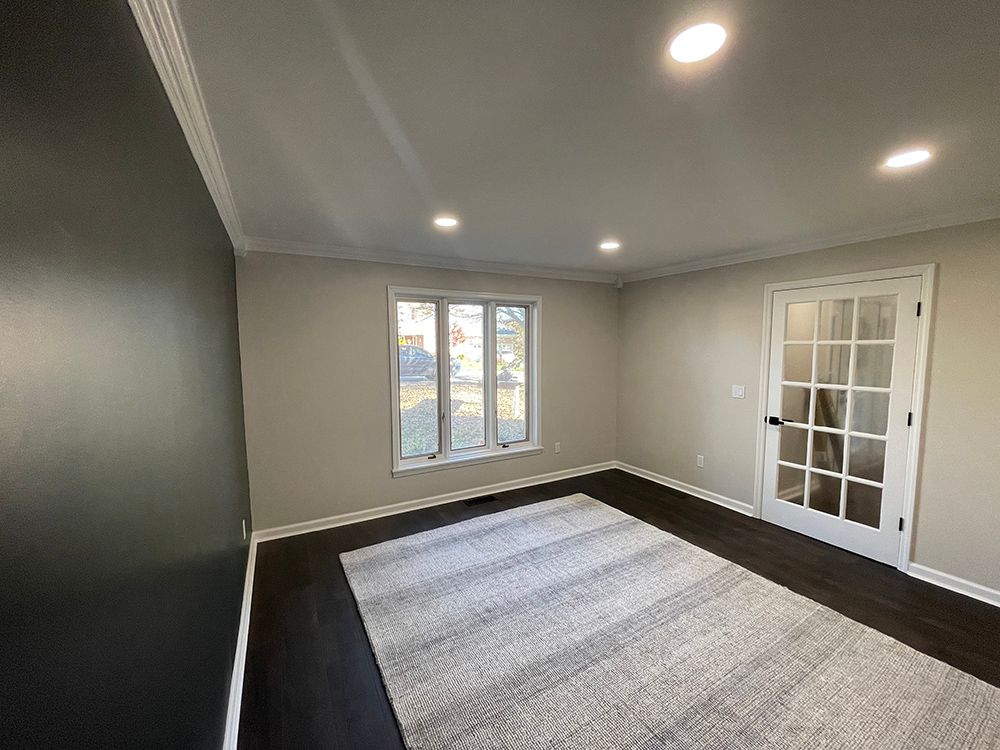 An empty living room with a rug and a french door