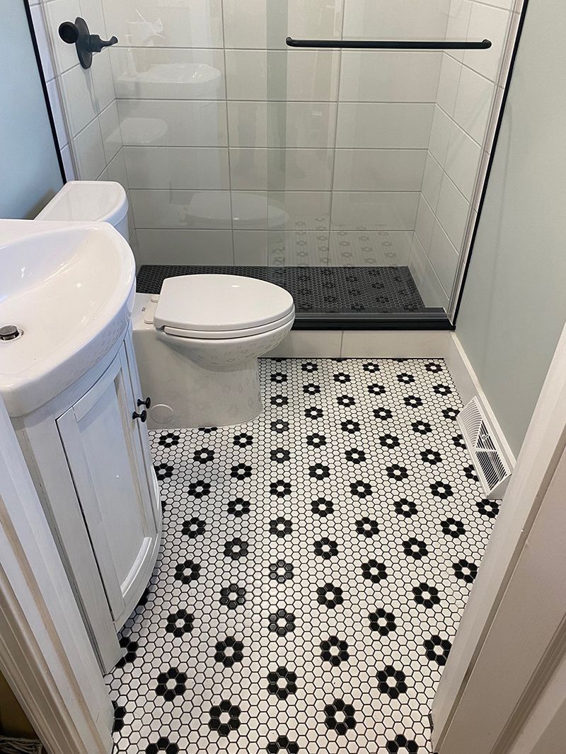 A bathroom with a toilet, sink and shower