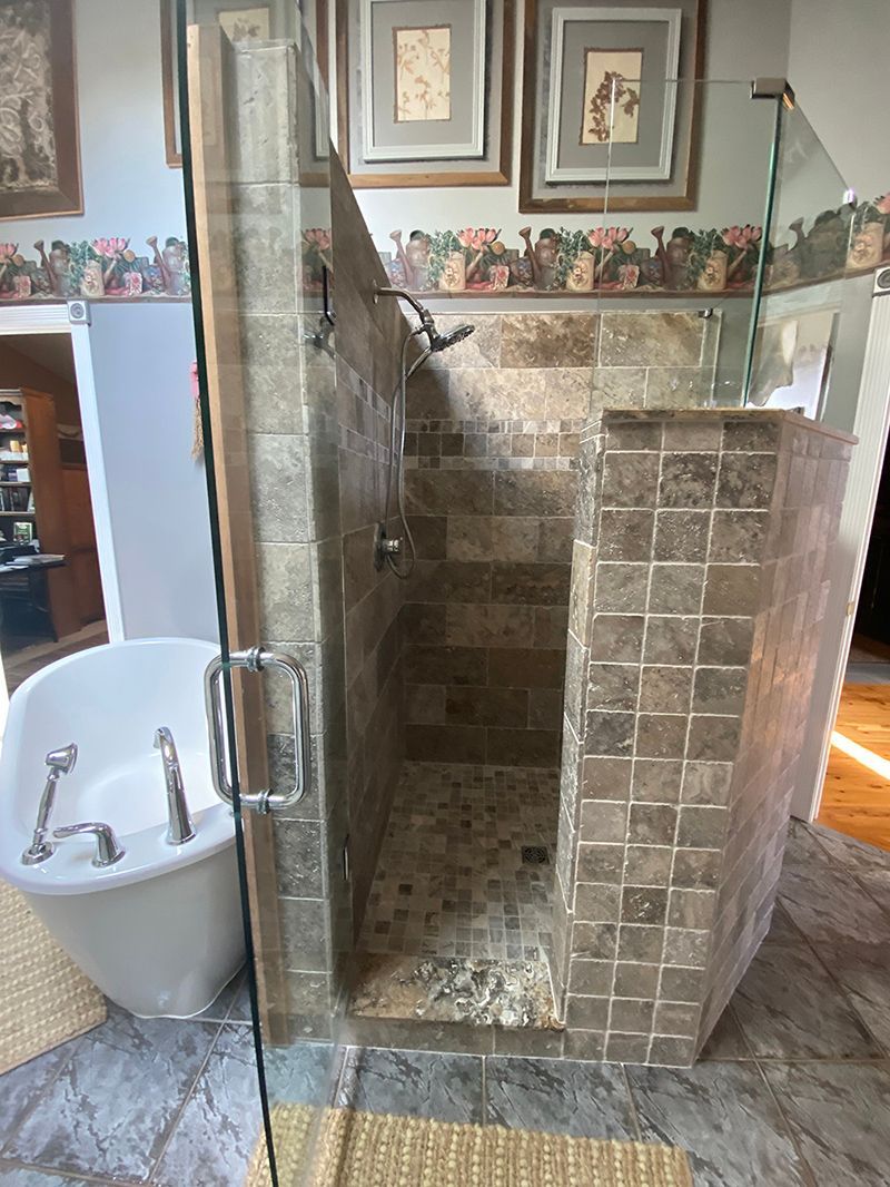 A bathroom with a tub and a walk in shower