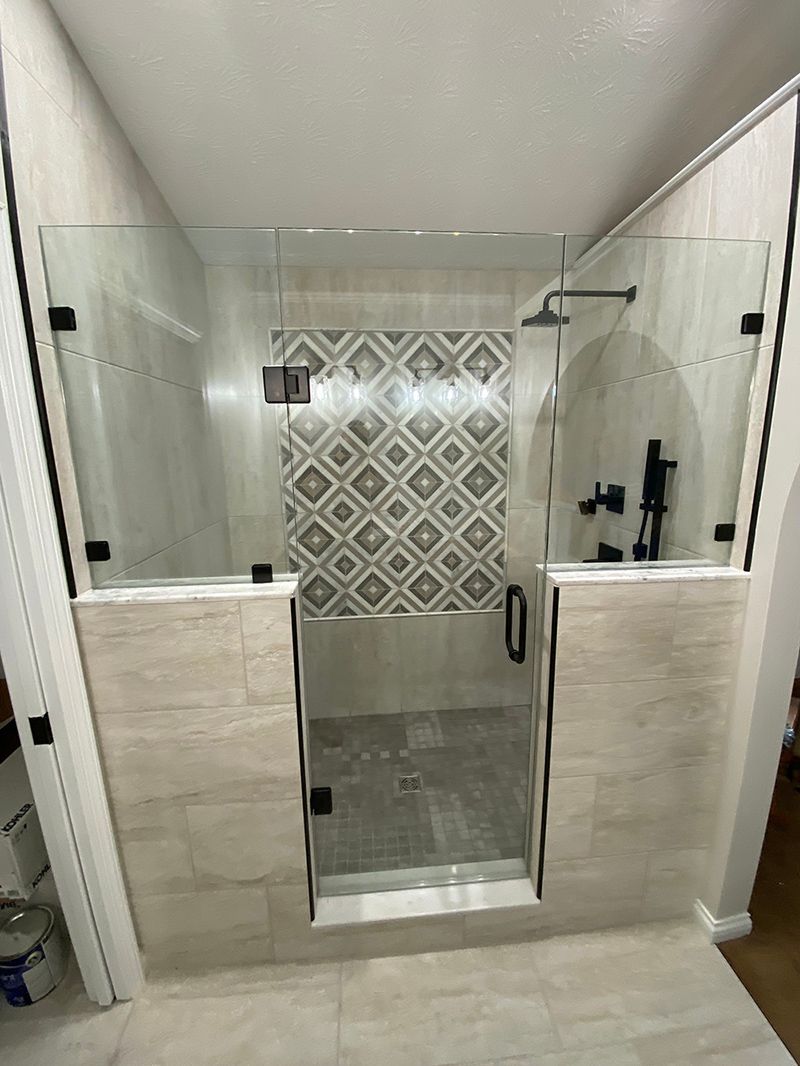 A bathroom with a walk in shower and a tiled wall