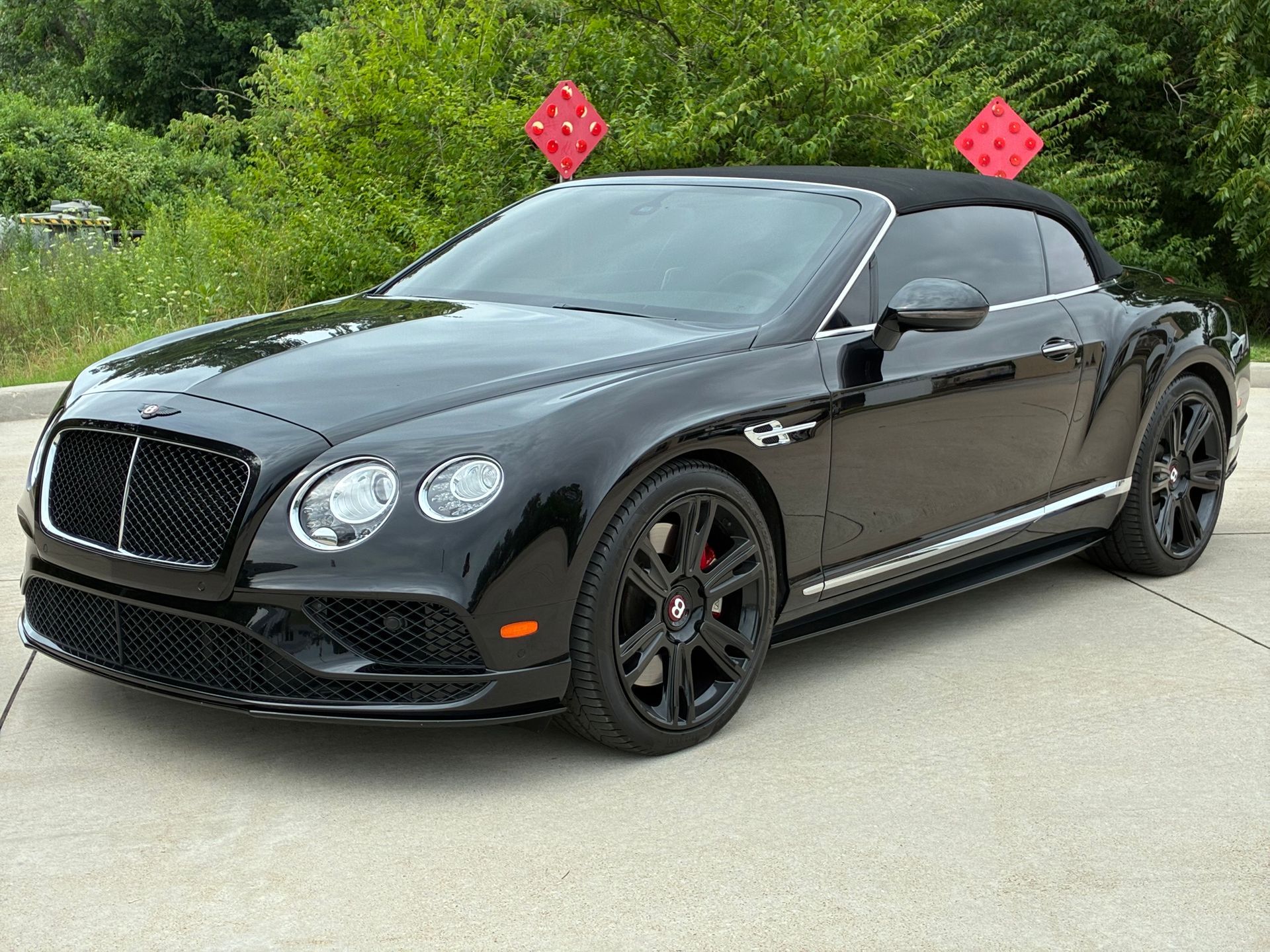 Black Bentley Continental GT convertible parked outdoors.