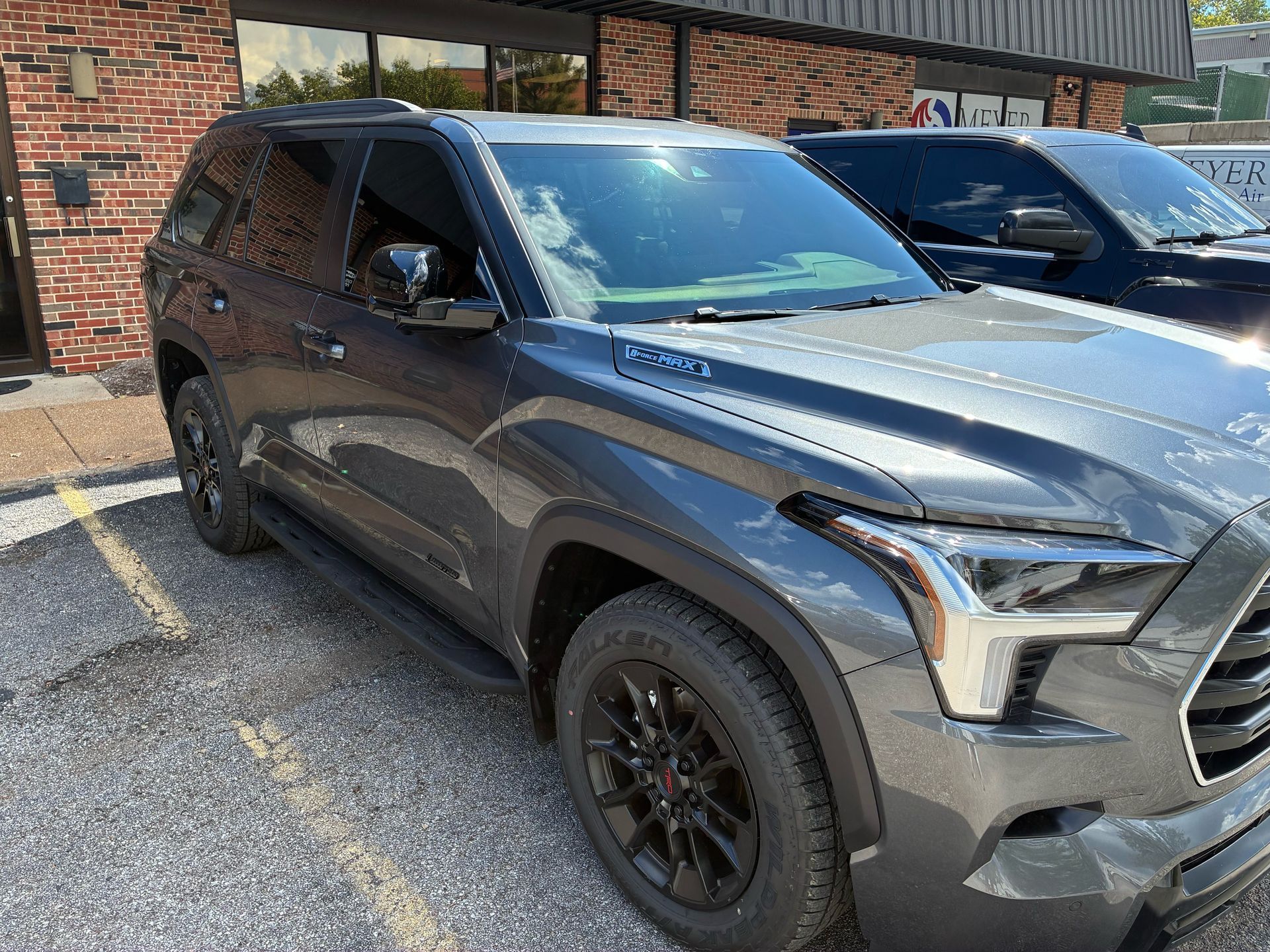 Gray Toyota Sequoia SUV parked outside a building with tinted windows.