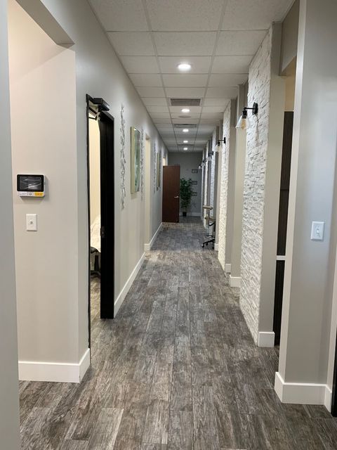 A long hallway leading to a dental office with a tiled floor.