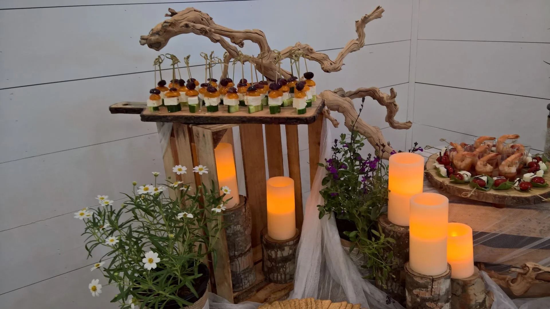 A table with candles , flowers , and food on it.