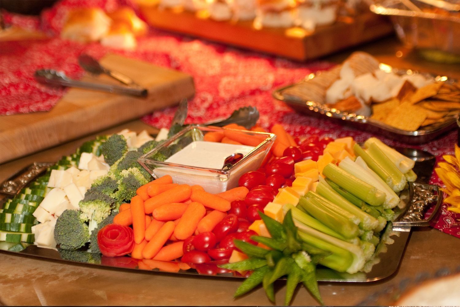 A tray of vegetables on a table with a bowl of dip