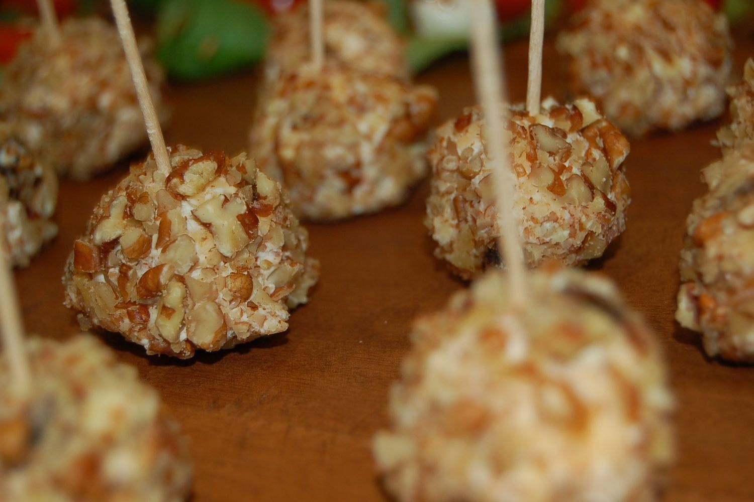 A bunch of cheese balls on toothpicks on a table.