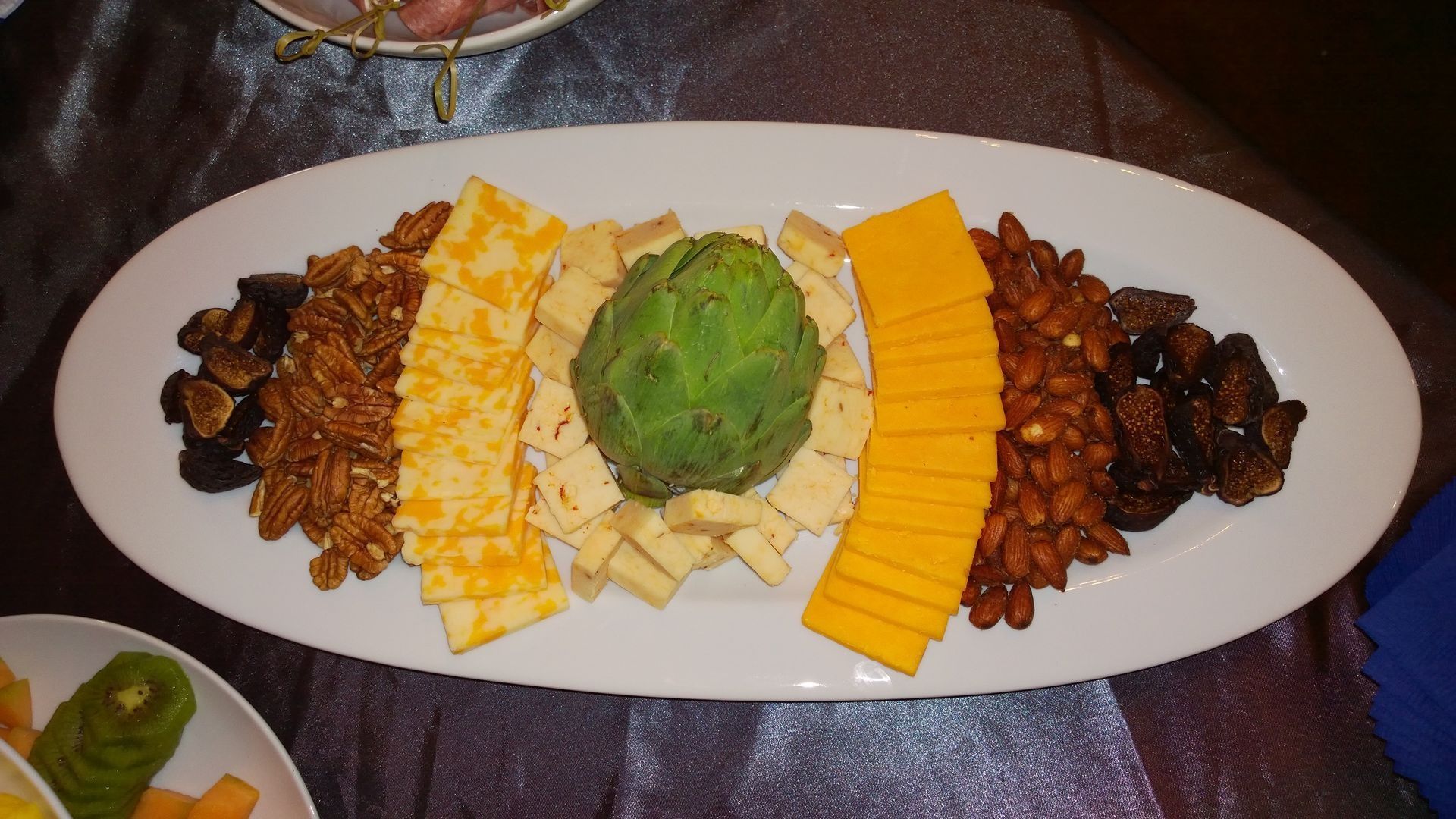 A white plate topped with cheese nuts and artichokes