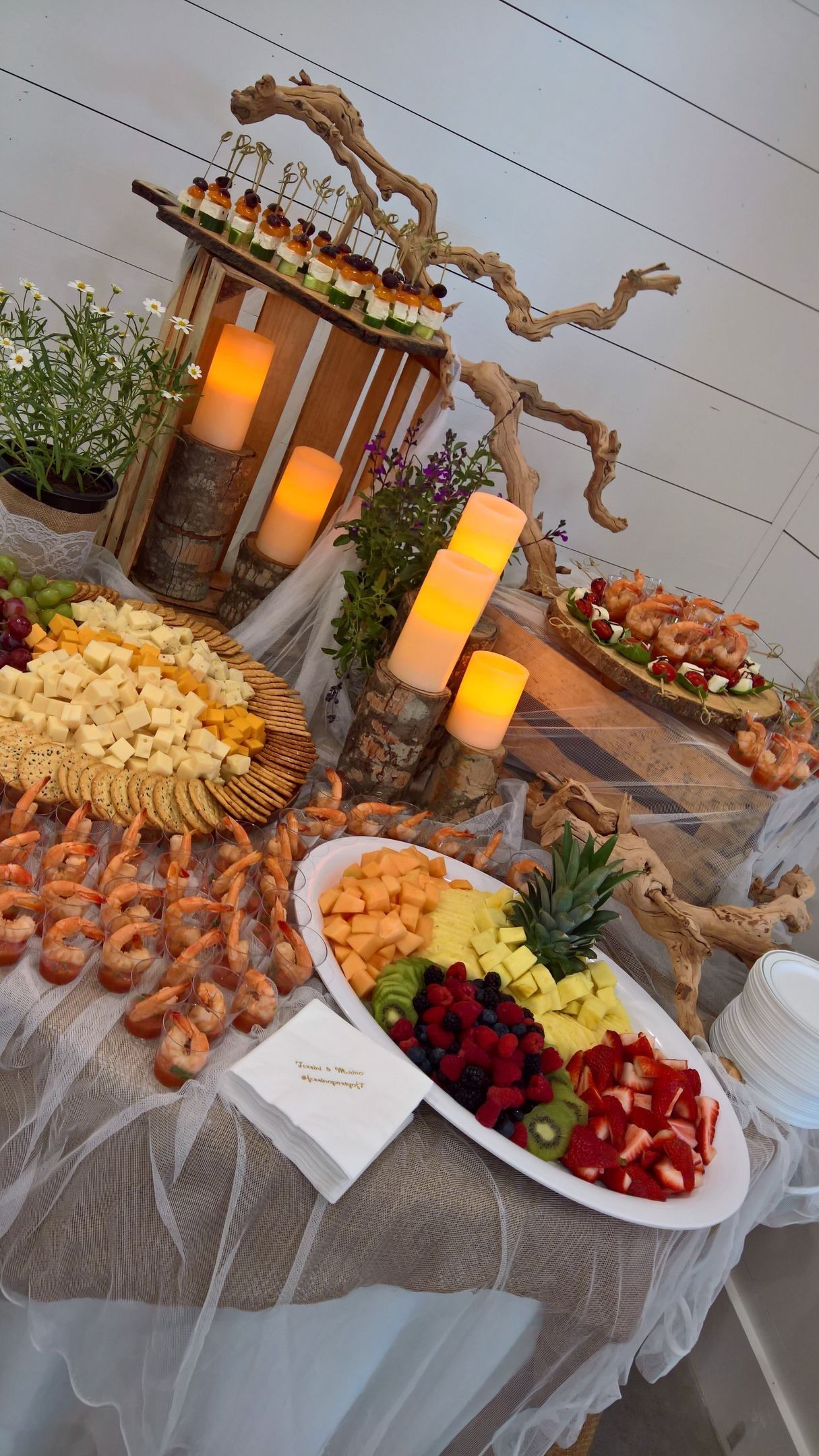 A buffet table with a variety of food and candles on it.
