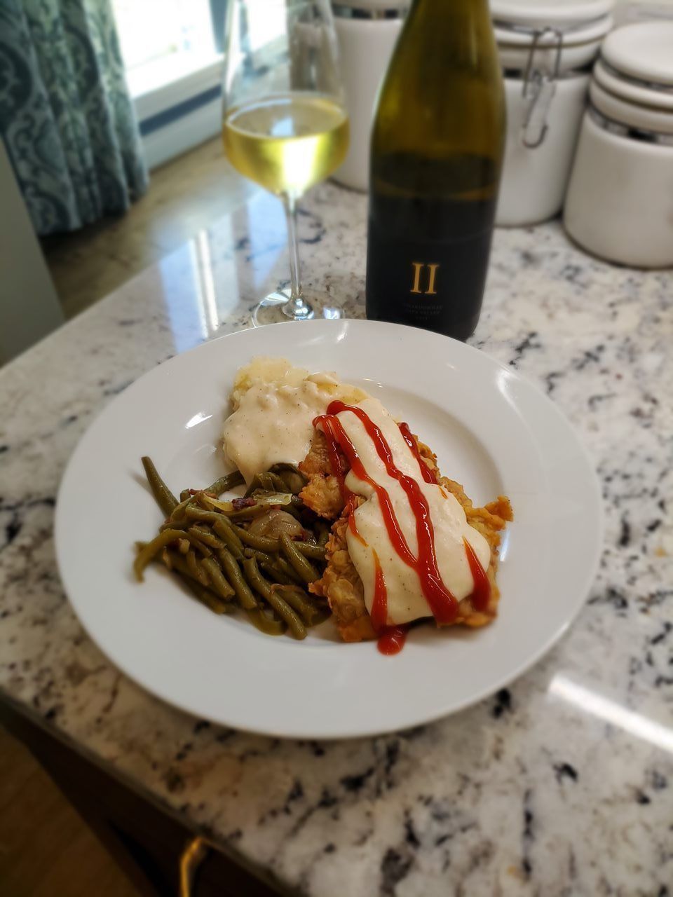 A bottle of ii sits next to a plate of food