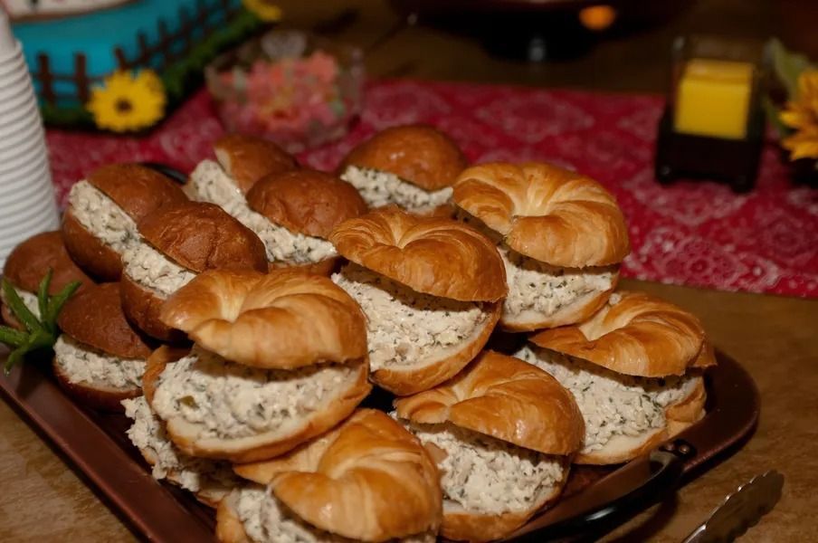 A tray of sandwiches on croissants on a table.