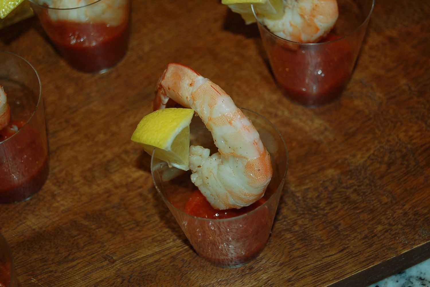 A close up of a shrimp cocktail in a cup on a table.