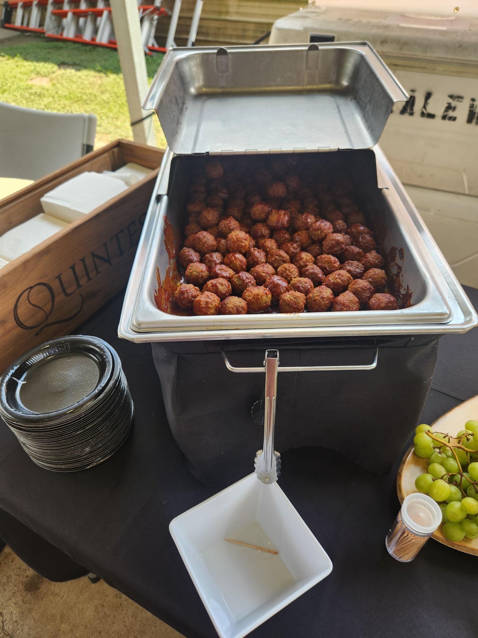 A buffet with meatballs and grapes on a table