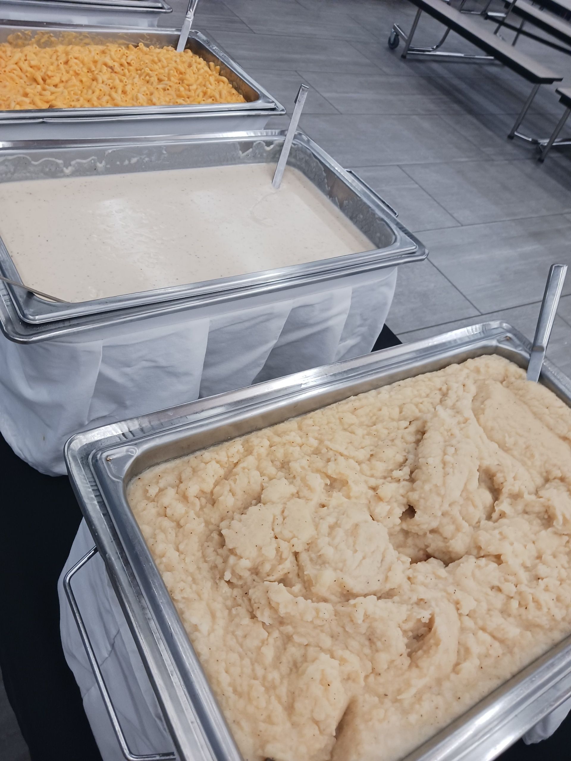 Three trays of food are sitting on a table.