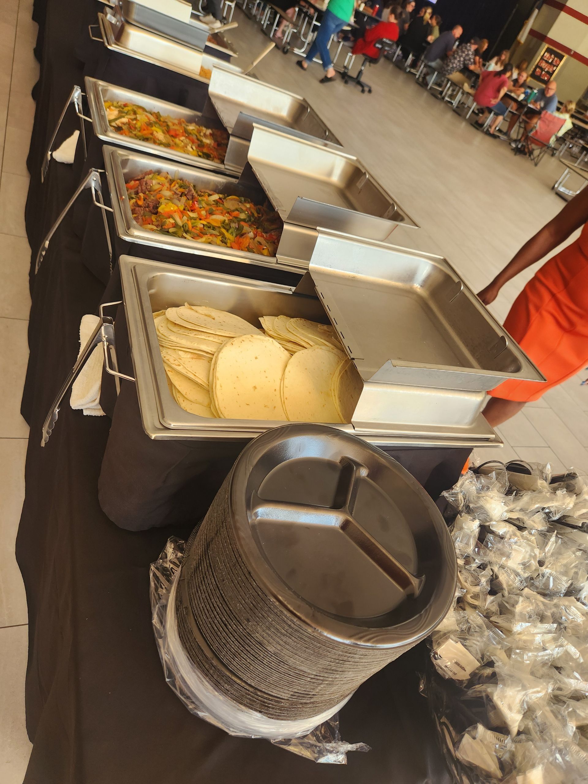 A buffet line with many trays of food on it