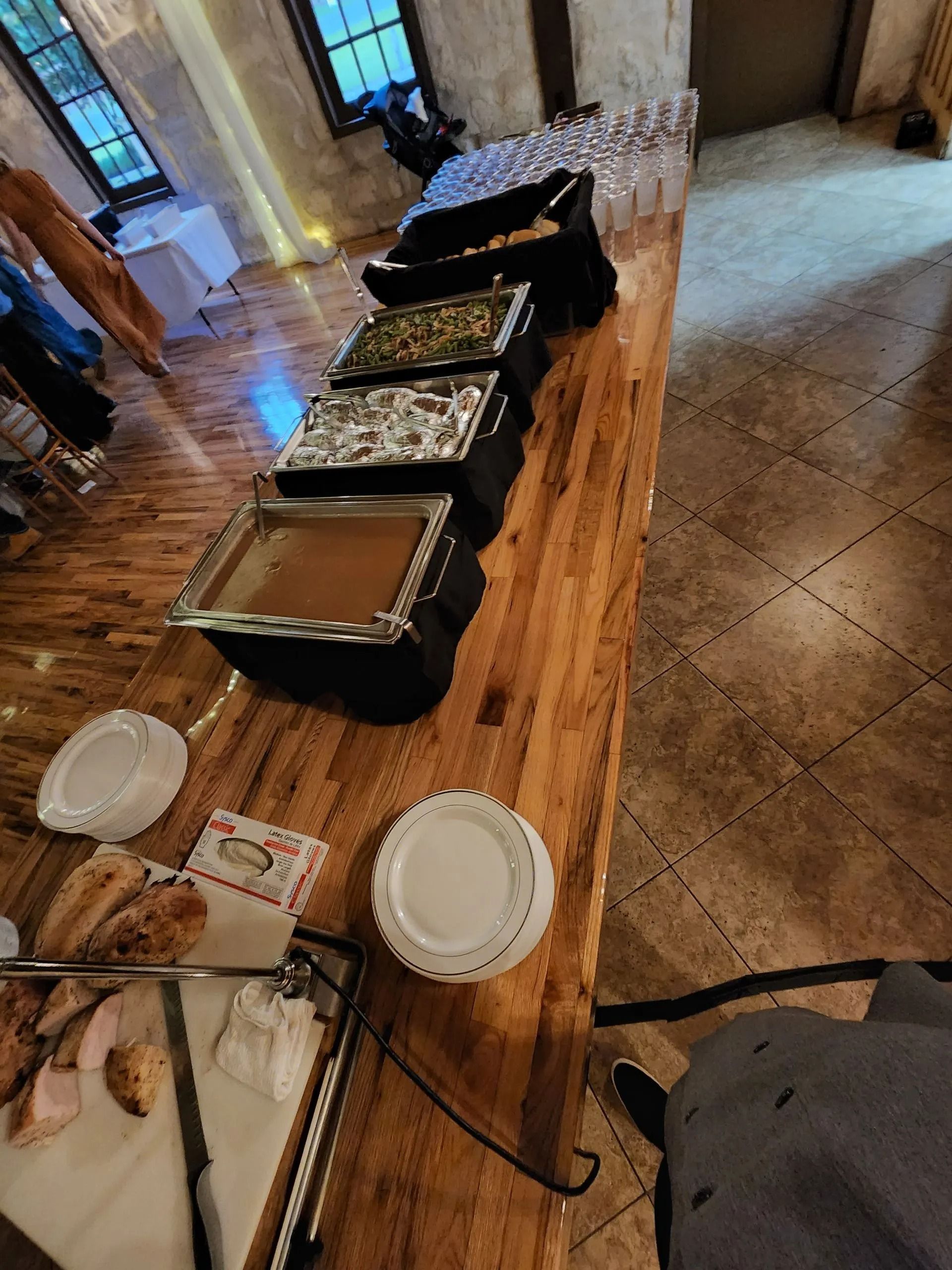 A wooden table with plates and bowls of food on it.