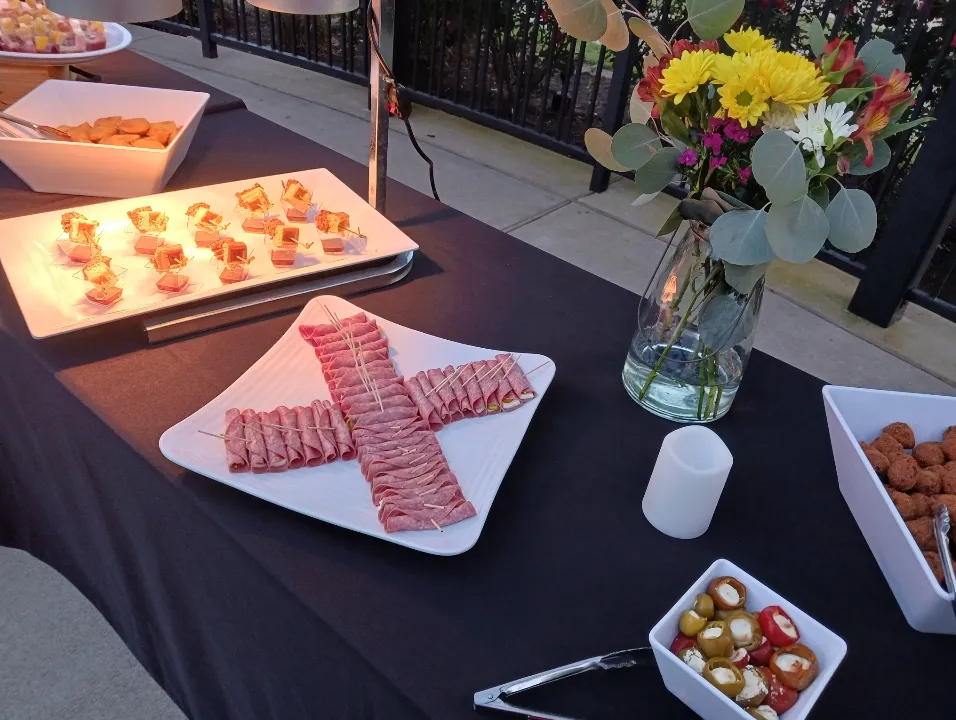 A table with plates of food and a vase of flowers on it