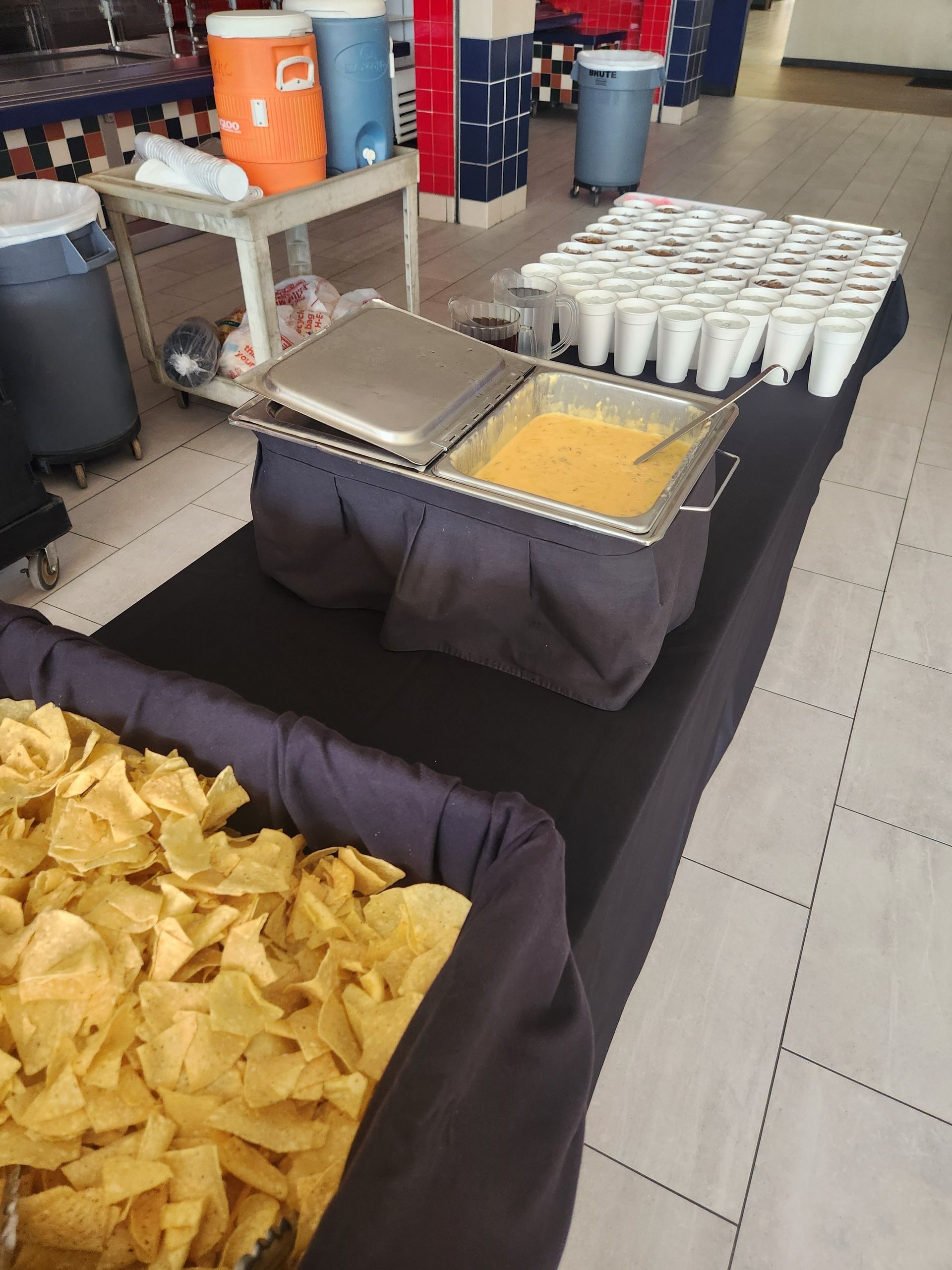 A buffet table with chips and drinks on it
