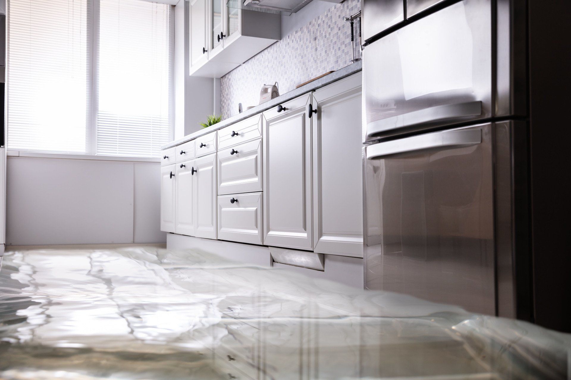 a kitchen with a flooded floor and stainless steel appliances .