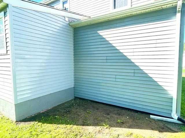 Exterior of a house with weathered siding; corner and lower portion exhibit green mildew. - after