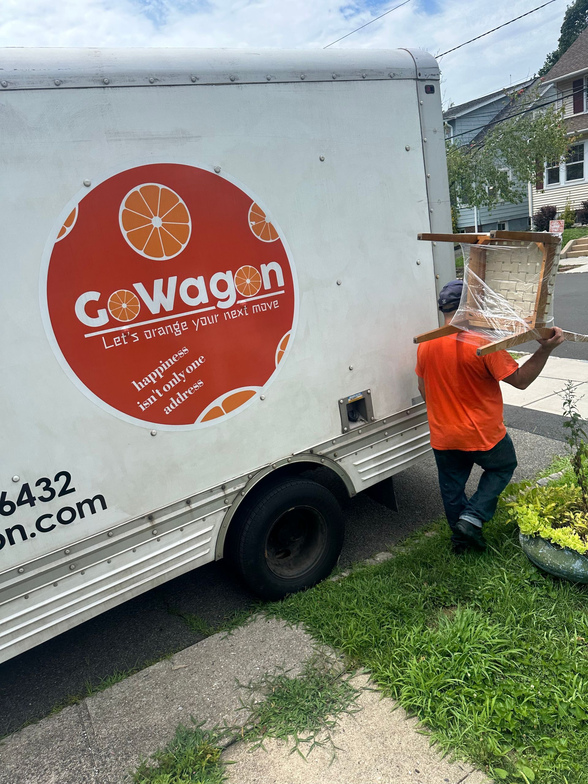 A man is carrying a chair in front of a cowagon truck