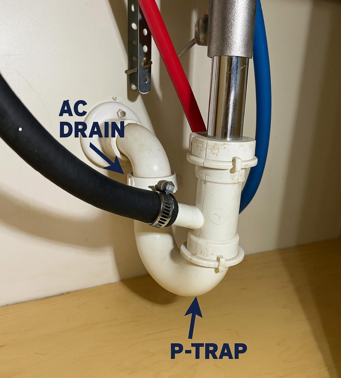 White plastic P-trap and A/C drain pipe