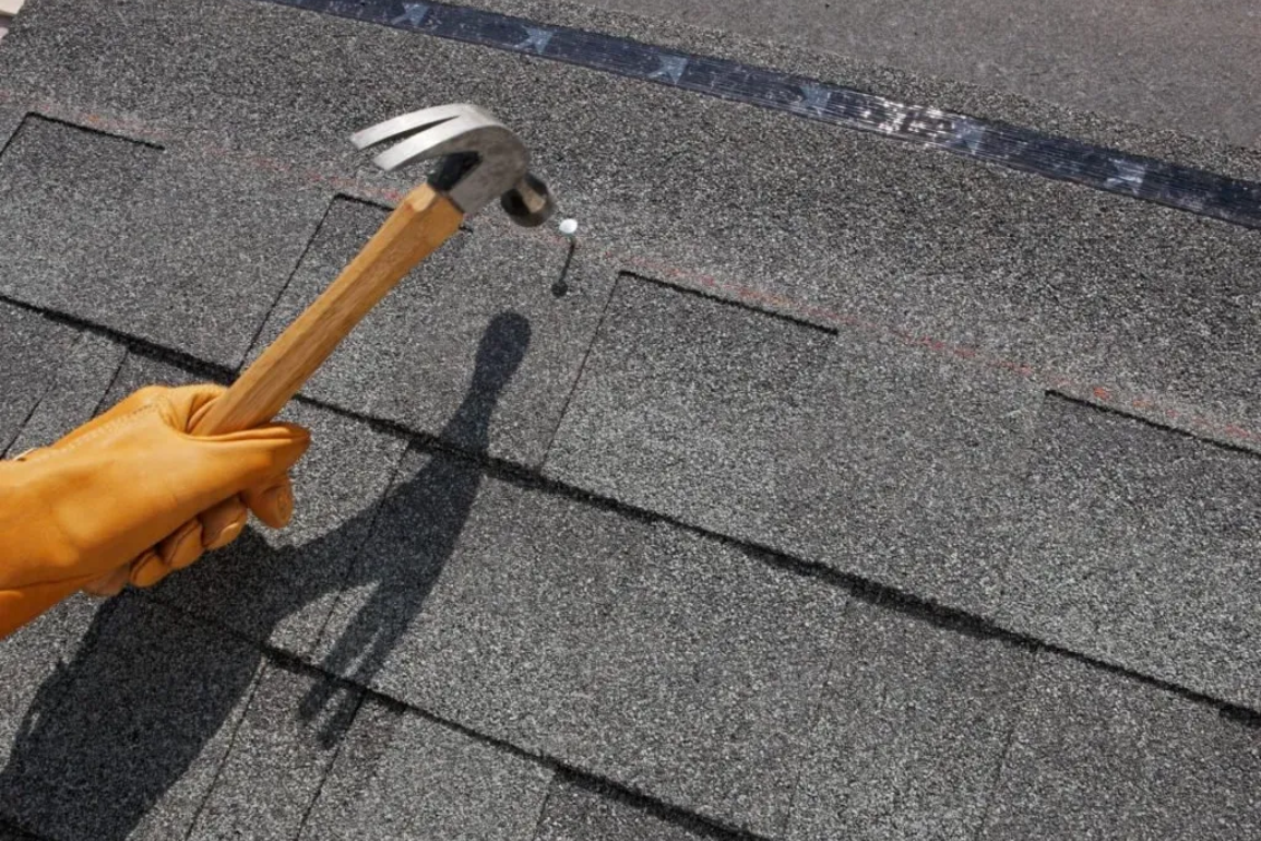 hammer nail into a roof shingle