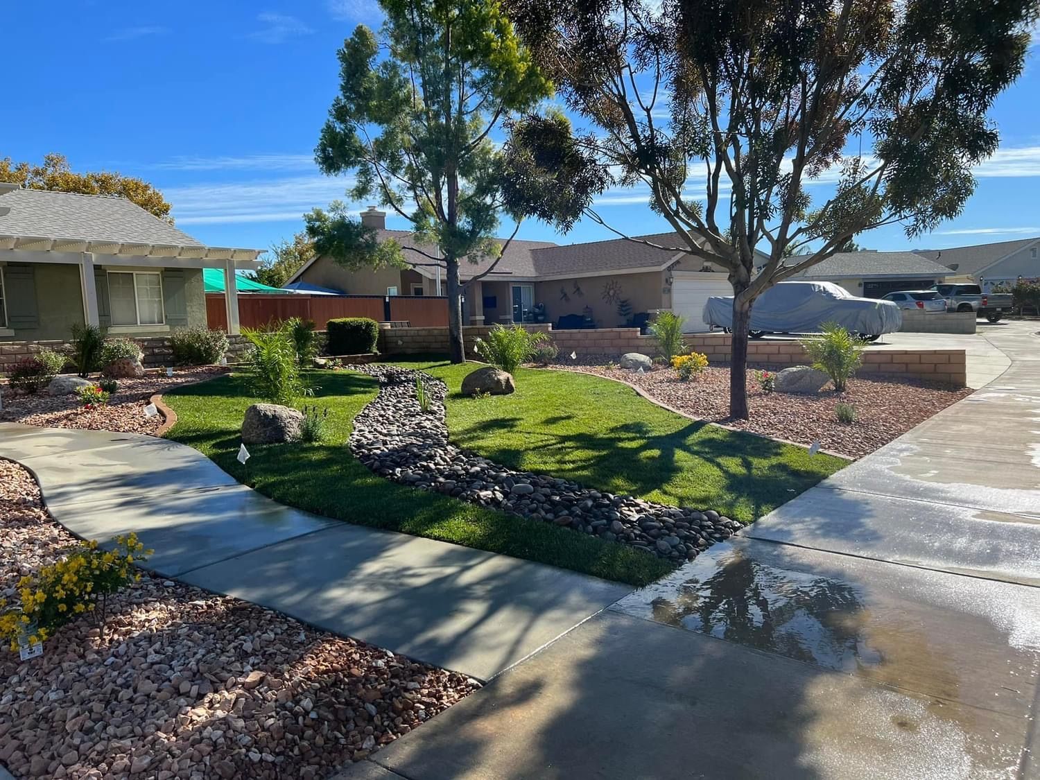 a sidewalk leading to a house with a lush green yard