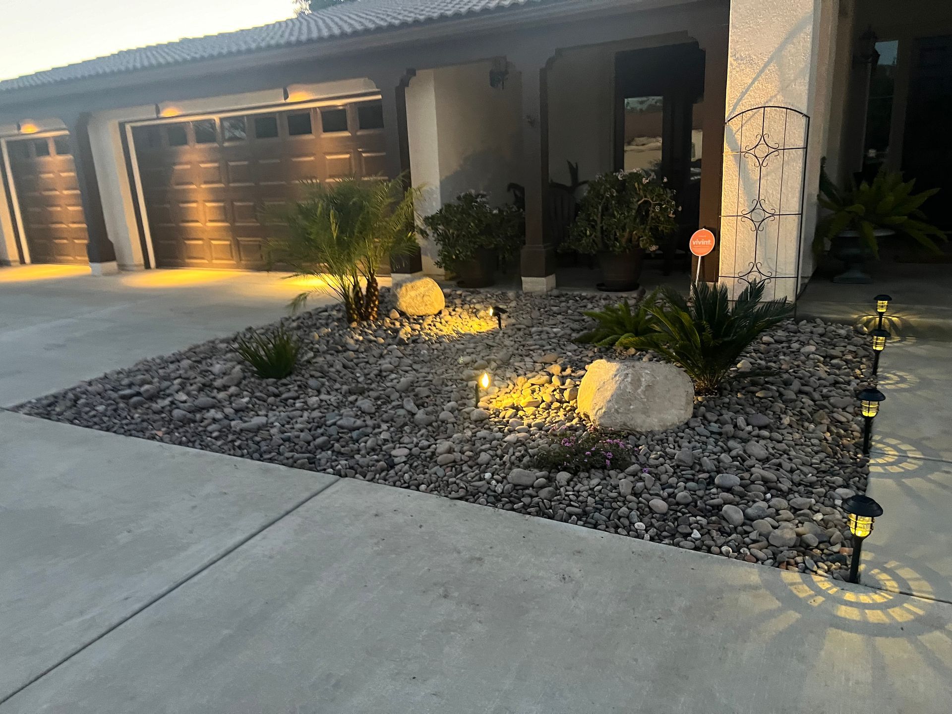 a house with a driveway and a garden in front of it