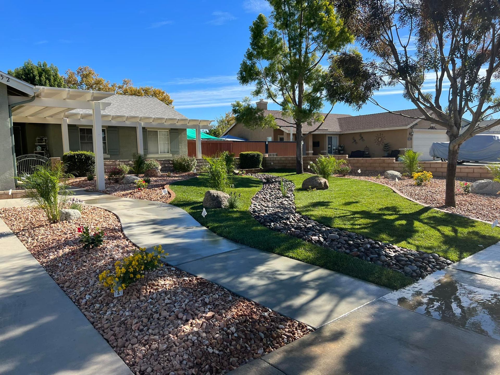 a house with a lush green lawn and a walkway in front of it