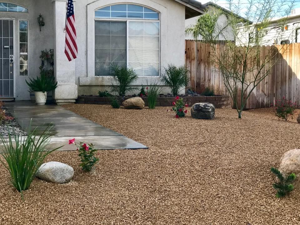 a house with an american flag on the front of it and a rock garden landscape