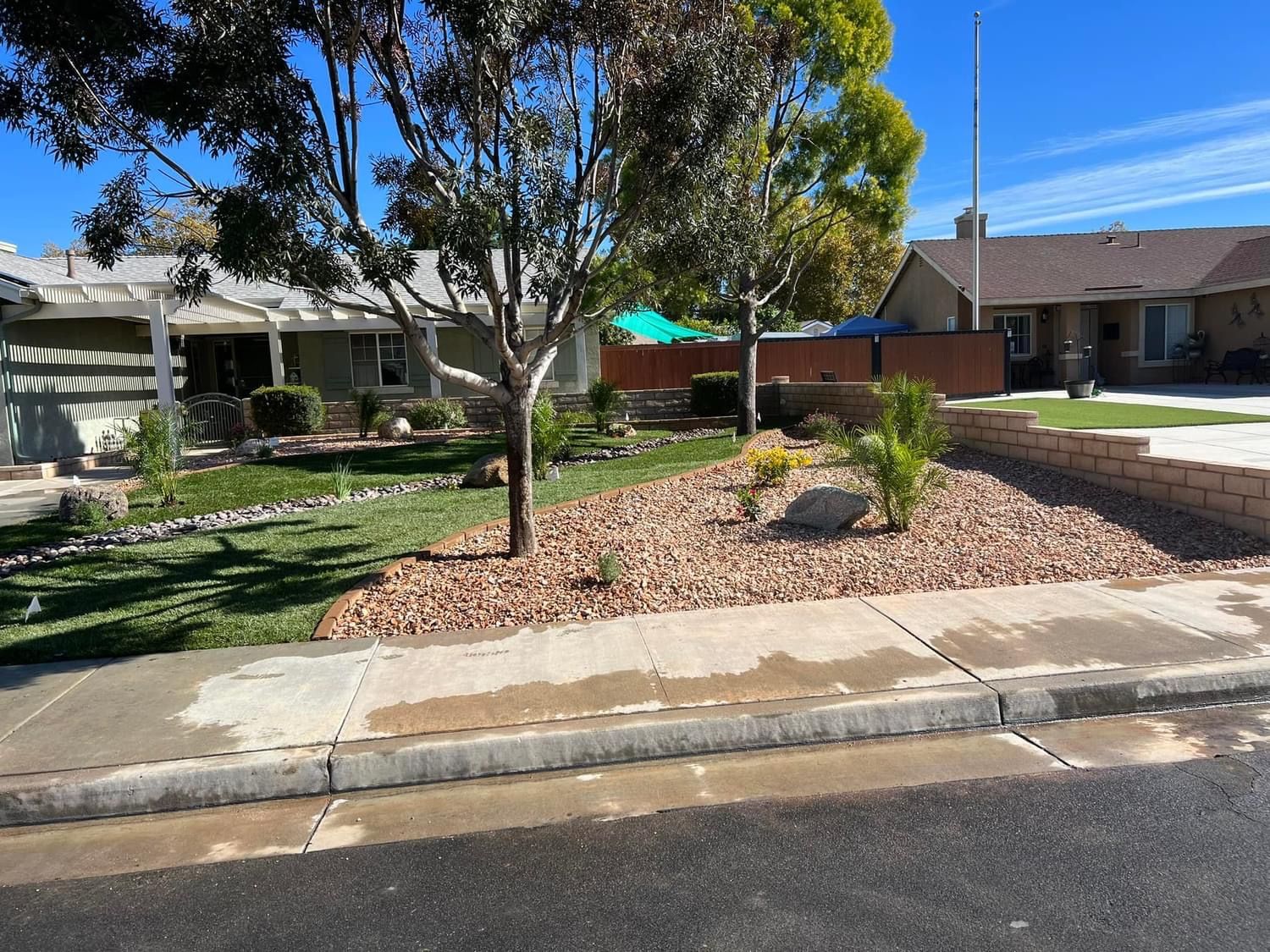 a house with a fence and a tree in front of it