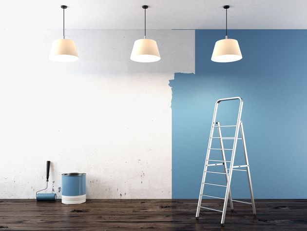 A room is being painted blue and white with a ladder.