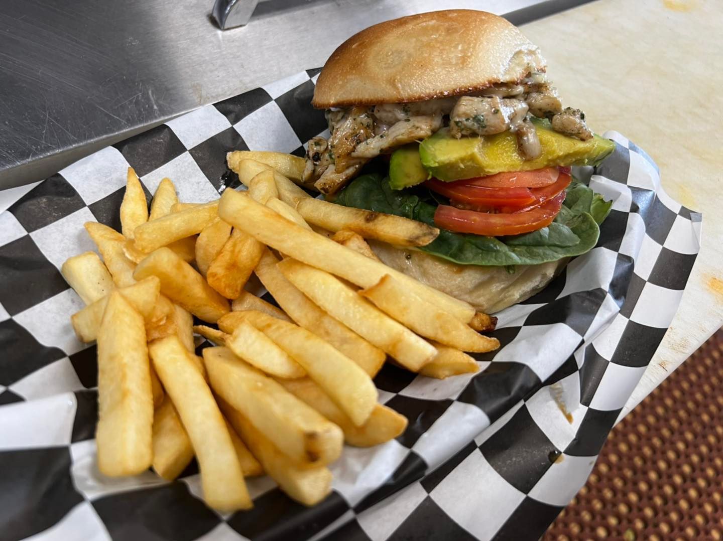 A hamburger and french fries on a checkered paper