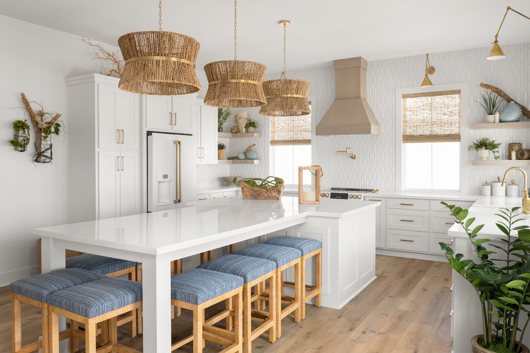 Bright modern kitchen with white cabinets, woven pendant lights, island seating, and wood floors