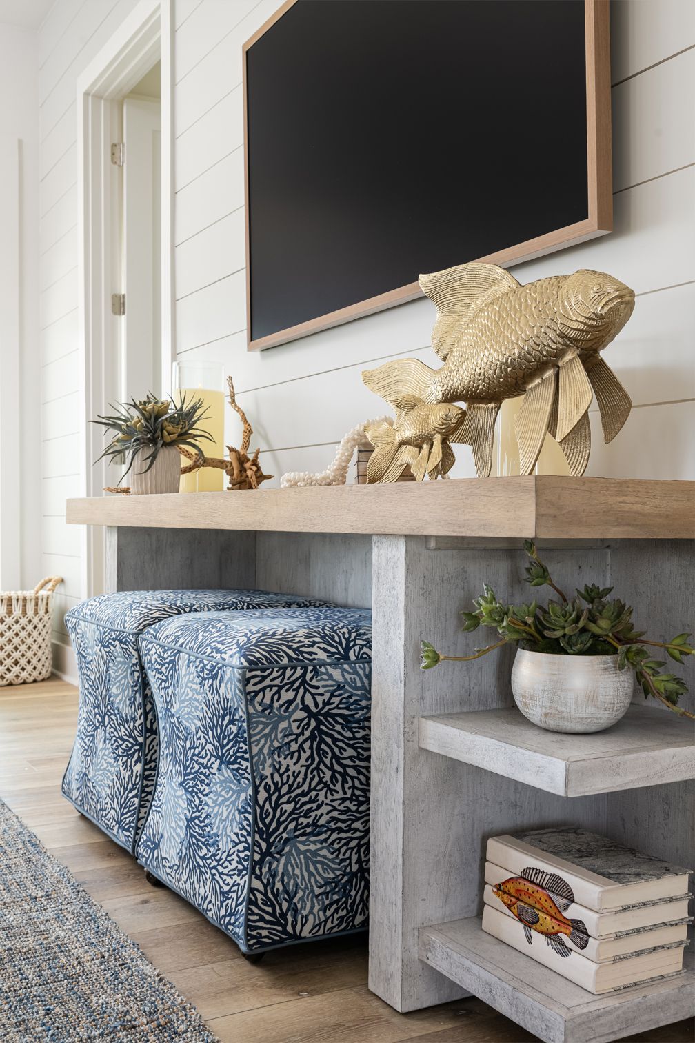 Modern farmhouse living room with TV, wood console, blue storage bench, and decorative accents