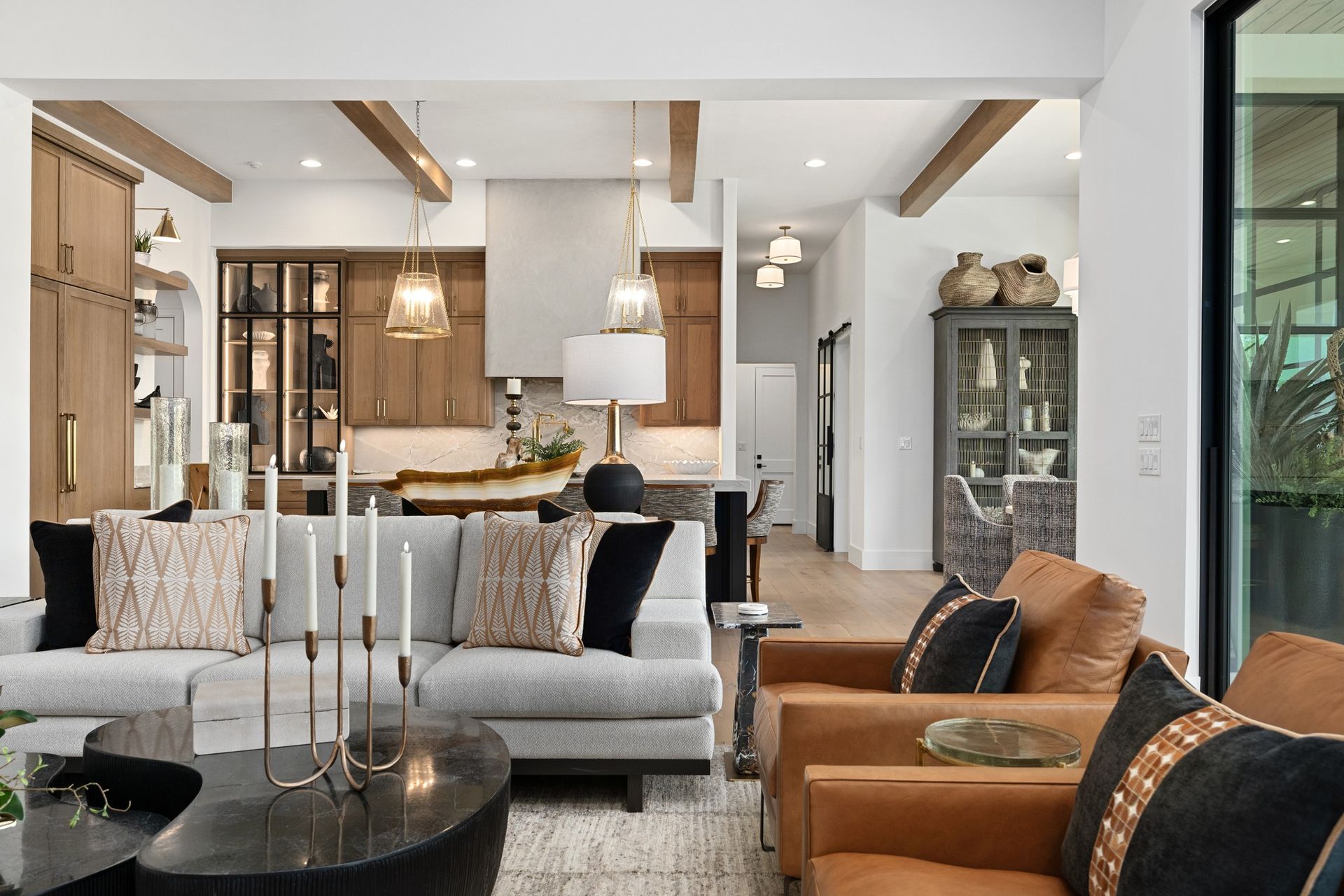 Modern living room with gray sofa, tan chairs, black coffee table