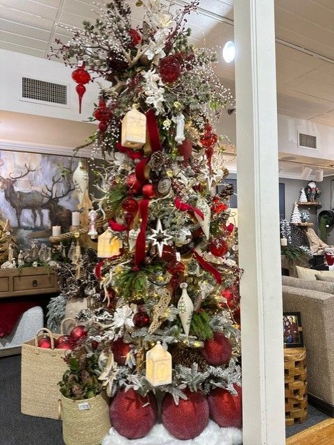 Decorated Christmas tree with red ornaments and gold lanterns in a store showroom