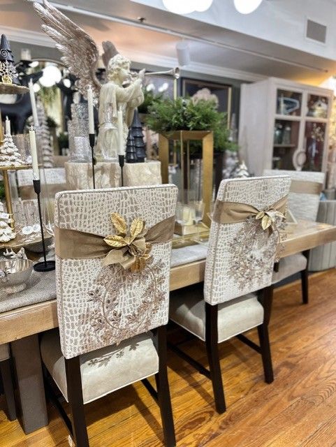 Decorative dining chairs with beige lace covers and gold bows in a bright, elegant interior