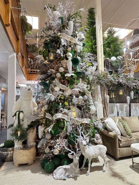 Decorated Christmas tree with silver and green ornaments in a cozy living room display