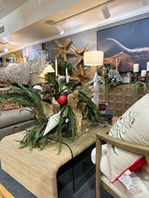 Holiday-decorated living room with a coffee table centerpiece, lamp, and mountains visible through the window
