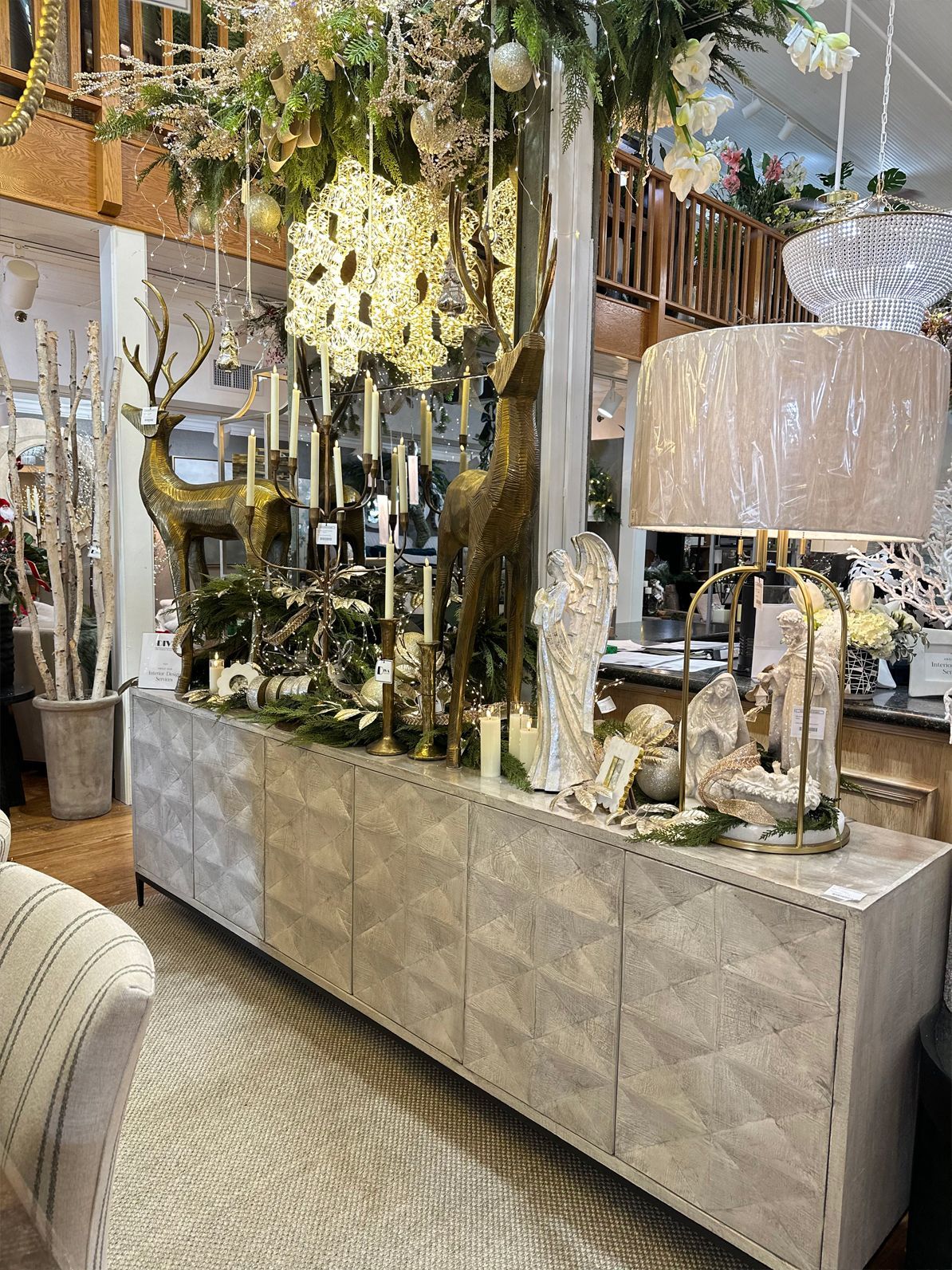 Decorative showroom display with mirrored cabinet, crystal chandeliers, and floral accents