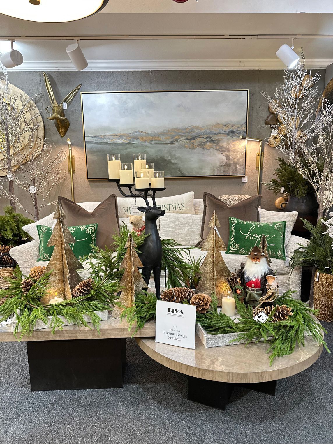 Decorated holiday showroom sofa with gold, green, and silver accents, candles, and floral arrangements