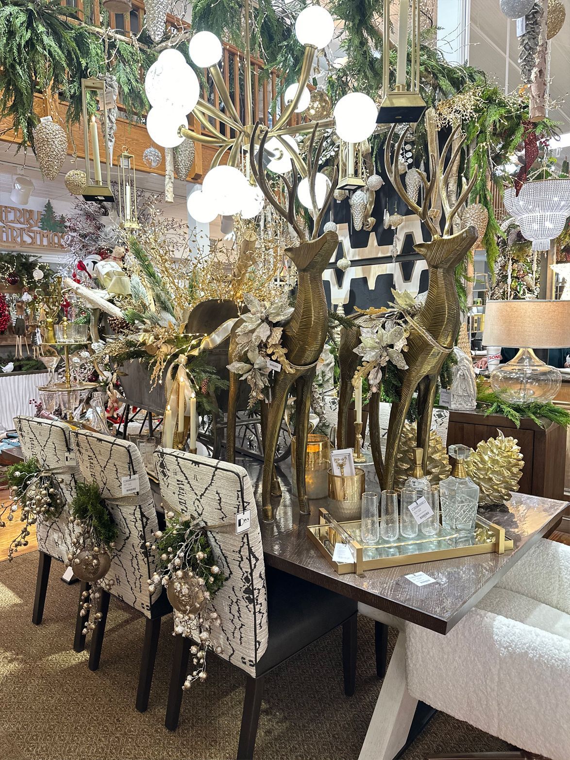 Elegant banquet table with gold decor, tall floral arrangements, and hanging white pendant lights