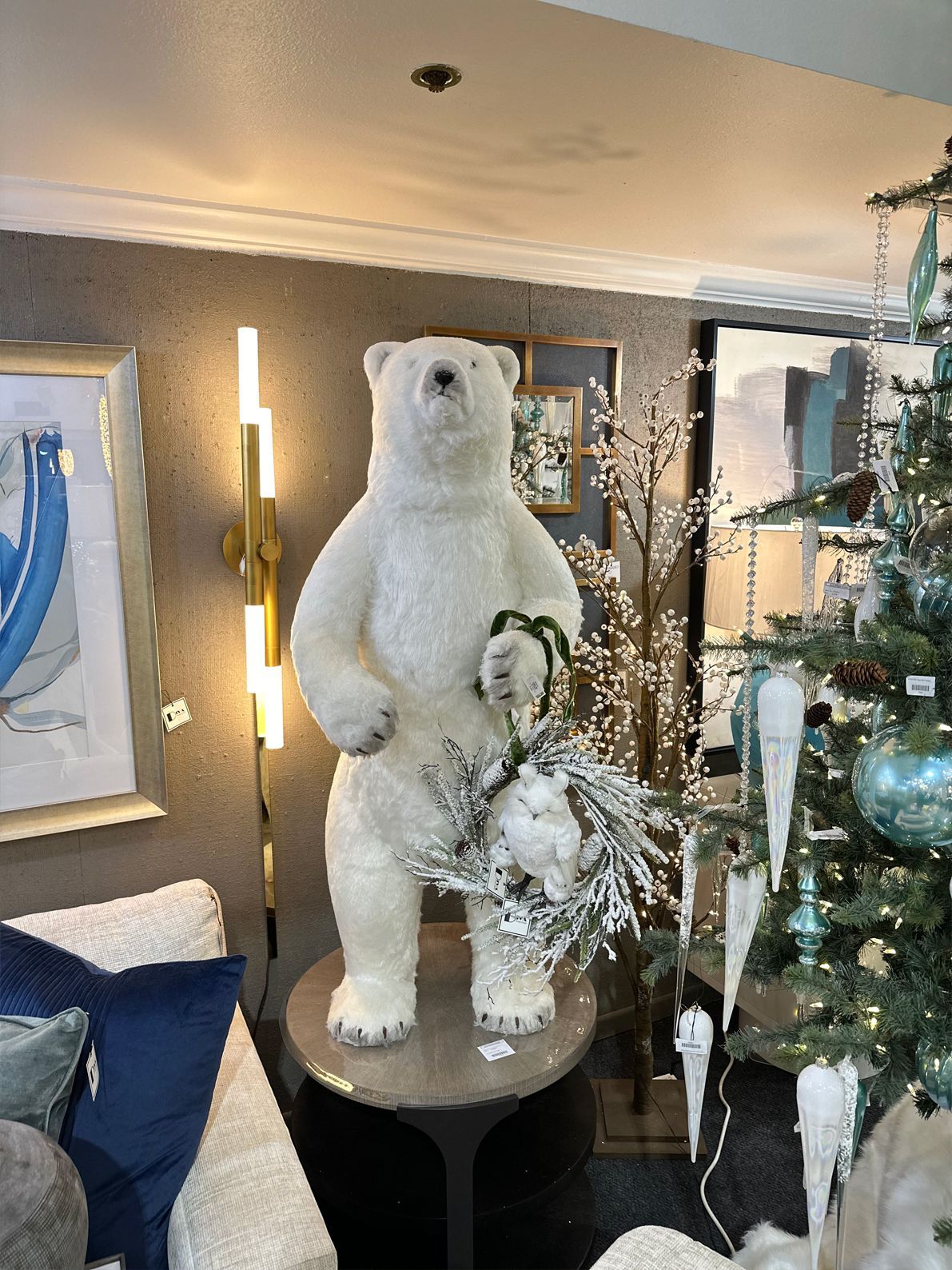 White bear sculpture in a decorated living room beside a small Christmas tree and floral arrangement