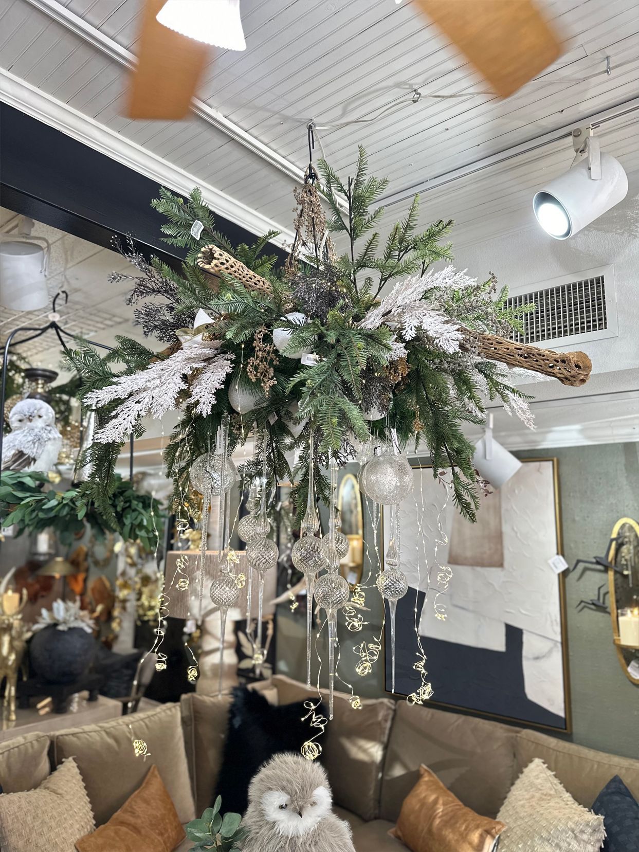 Decorative floral chandelier with hanging crystals in a cozy indoor lounge with sofas and ceiling fans