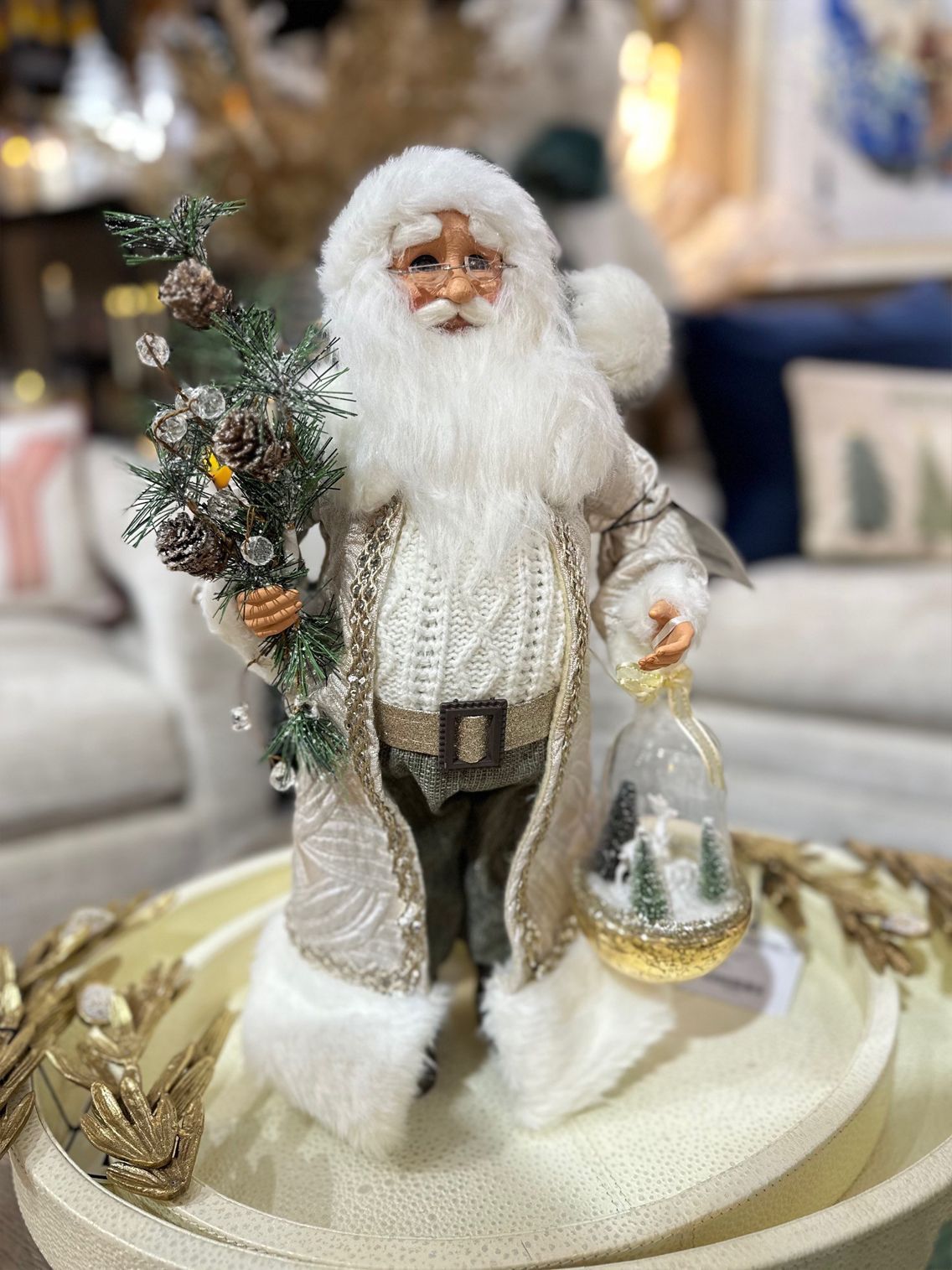 Santa figurine with a Christmas tree and lantern on a decorative snowy base