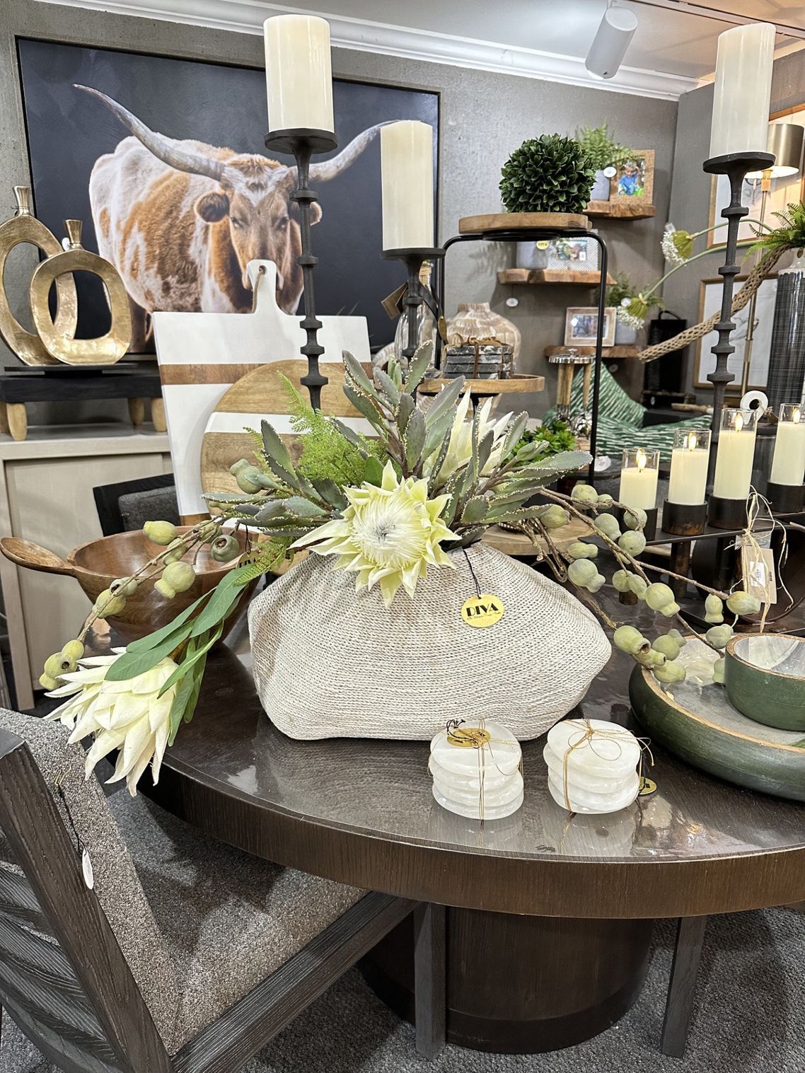 Decorative tabletop display with candles, flowers, woven pumpkins, and rustic autumn decor