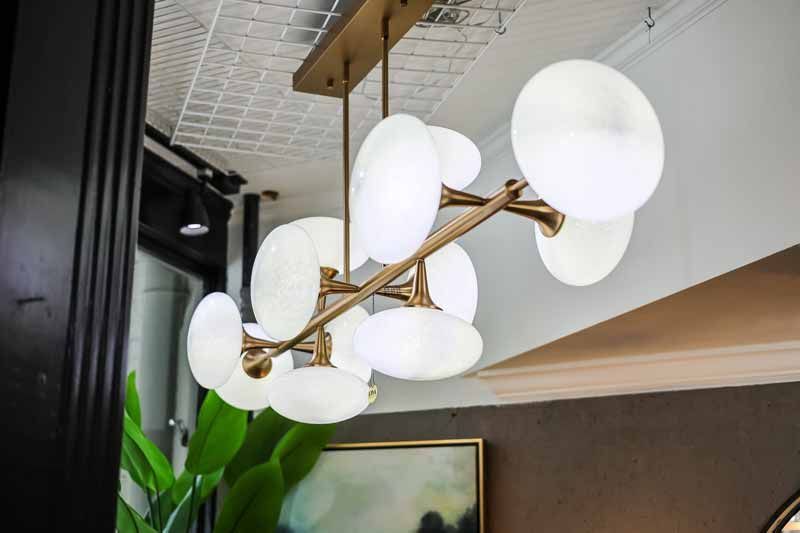 Modern gold chandelier with white globe shades hanging from a ceiling indoors