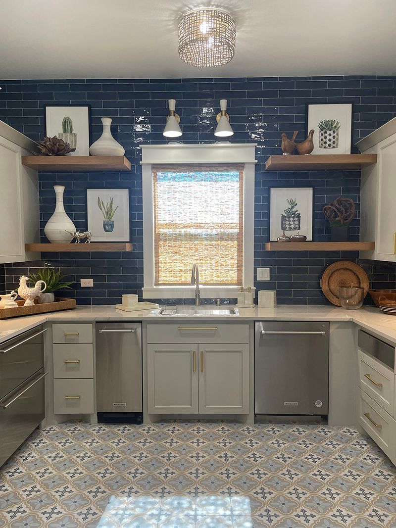 Kitchen with dark blue brick backsplash, white cabinets, open shelves, and patterned floor tiles.
