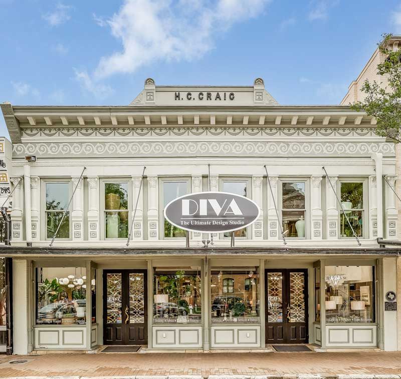 Historic white storefront with large windows and a central “DNA” sign under a blue sky